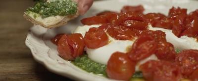 Burrata con pesto de rucula y cherrys asados